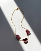 Akti plum ceramic necklace with gold chain, handmade organic petal forms in natural light and shadow