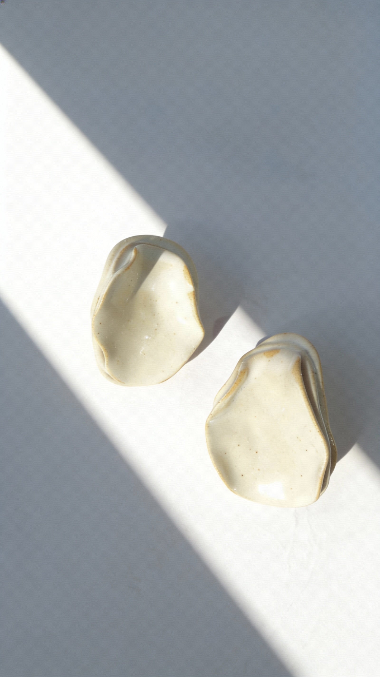 Anthi white ceramic statement earrings, handmade folded petal forms in natural light and shadow