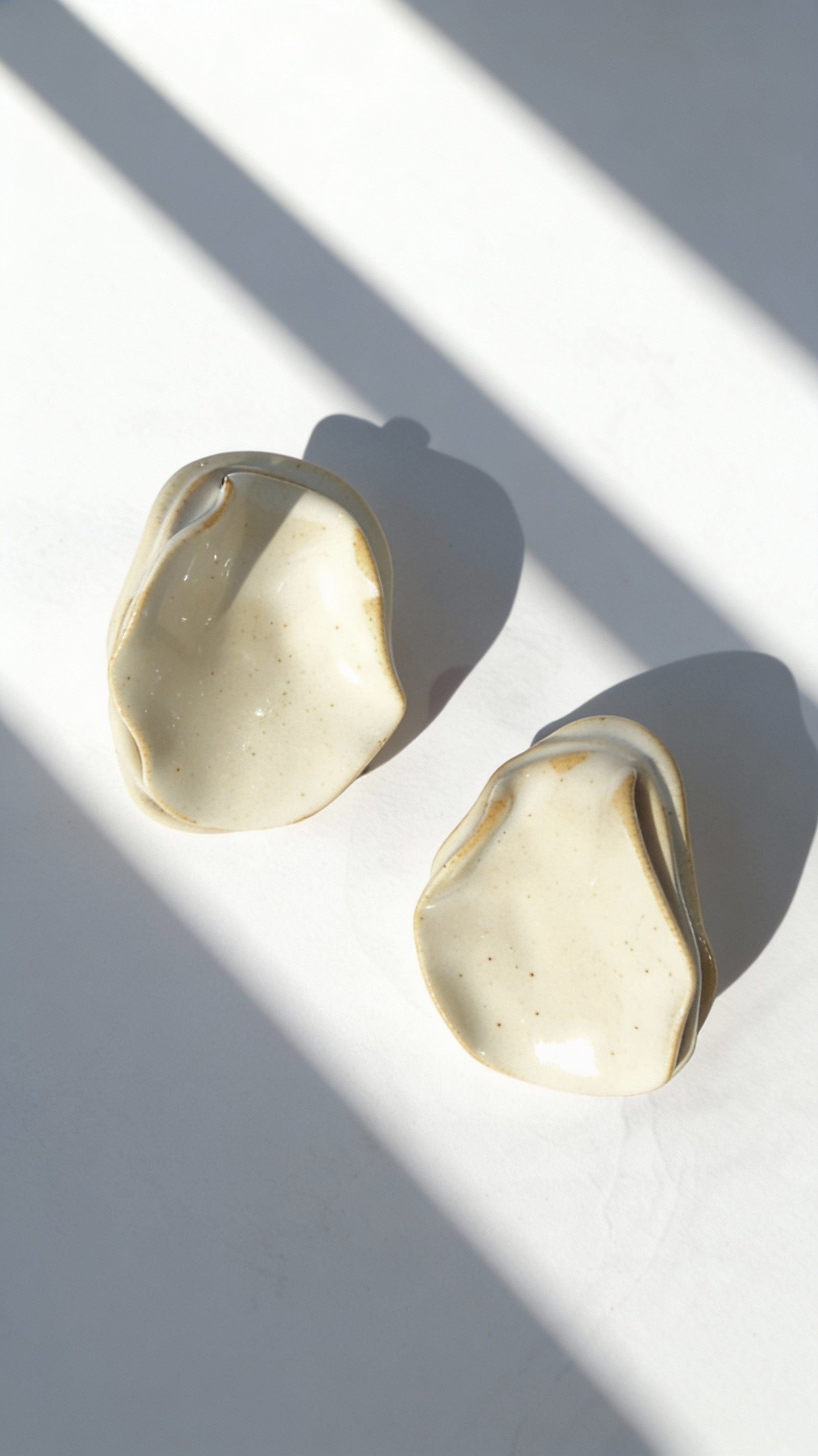 Anthi white ceramic statement earrings, handmade folded petal forms in natural light and shadow